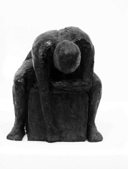 Foroverbøjet siddende kvinde på klods