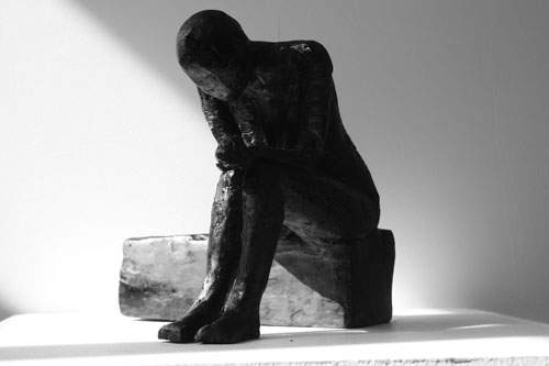 Siddende kvinde på lang klods