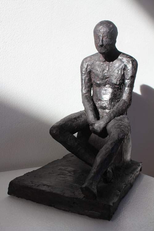 Siddende mand på sokkel