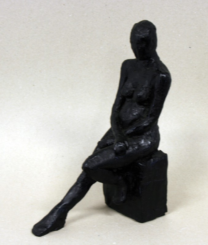 Kvinde siddende på klods med strakte ben