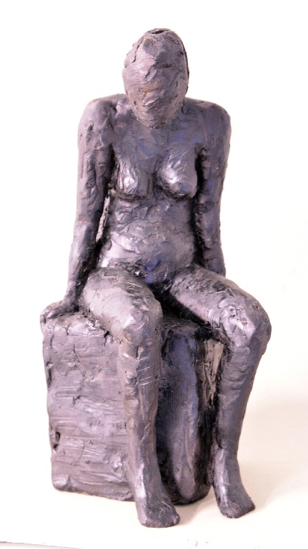 Kvinde siddende på hjørnet af klods