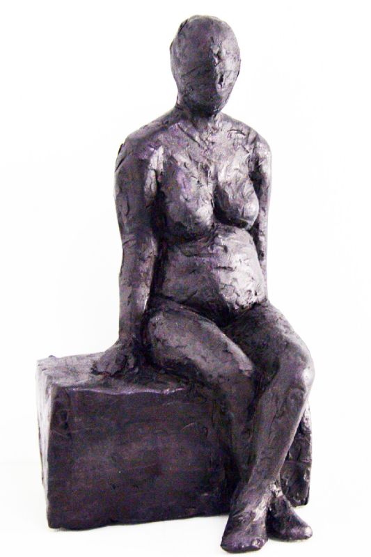 Kvinde siddende på klods