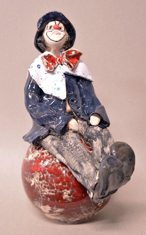 Siddende klovn på stor kugle