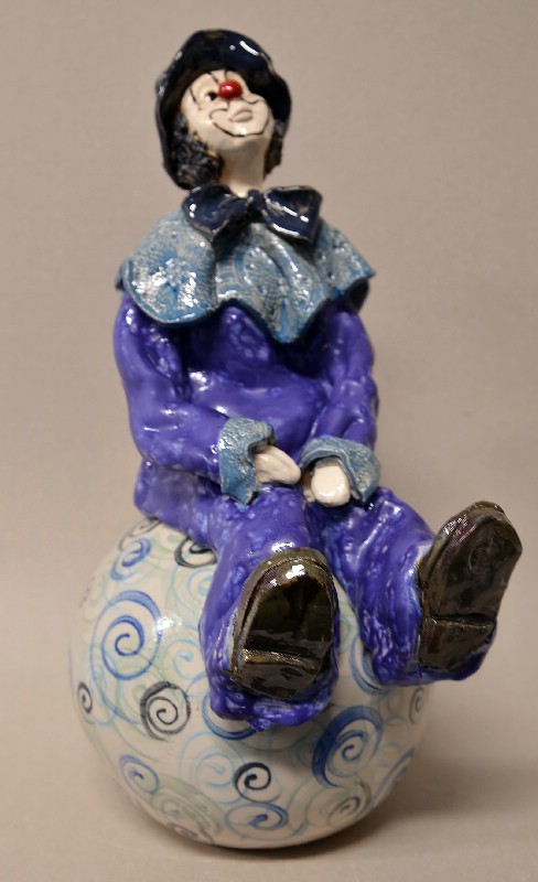 Siddende klovn på stor kugle