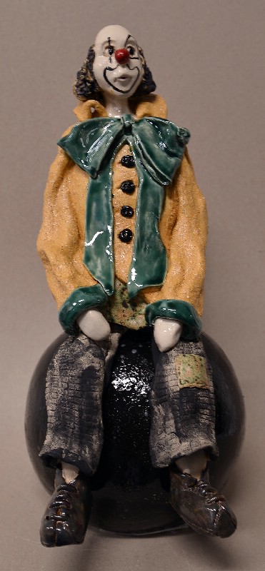 Siddende klovn på stor kugle