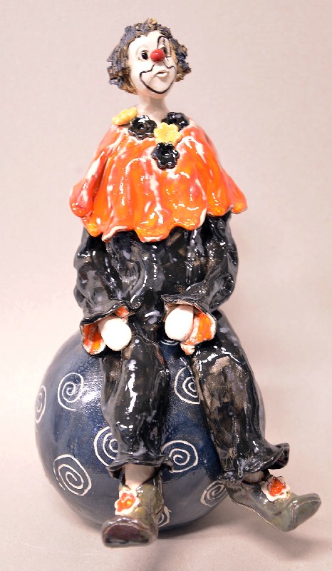 Siddende klovn på stor kugle