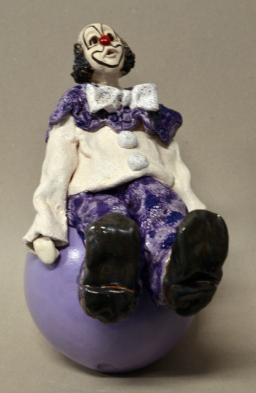 Siddende klovn på stor kugle