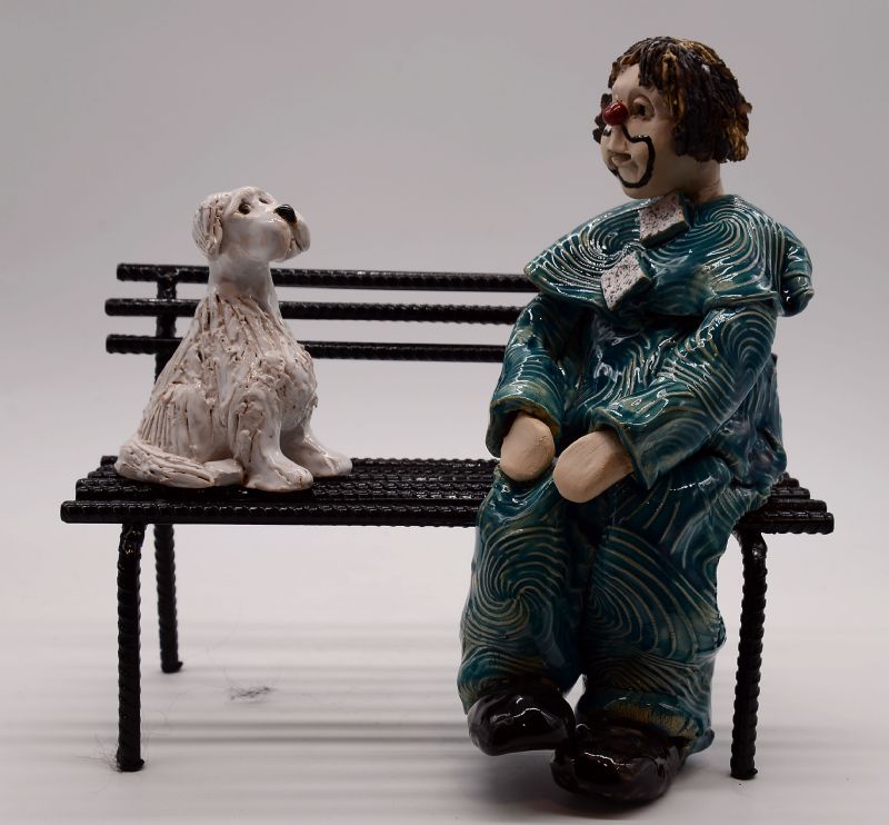 Klovn med hund på bænk