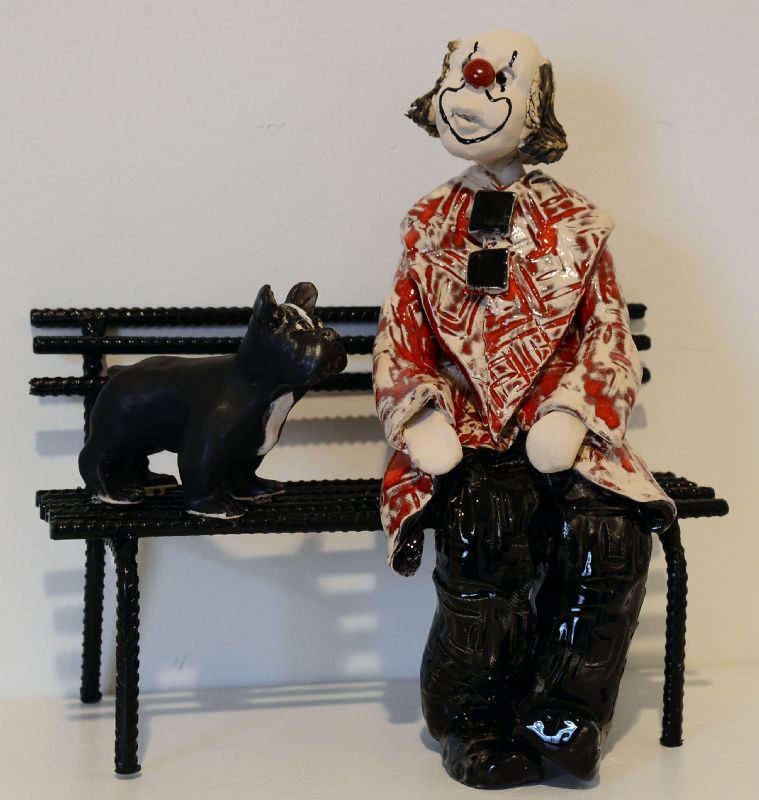 Klovn med hund på bænk