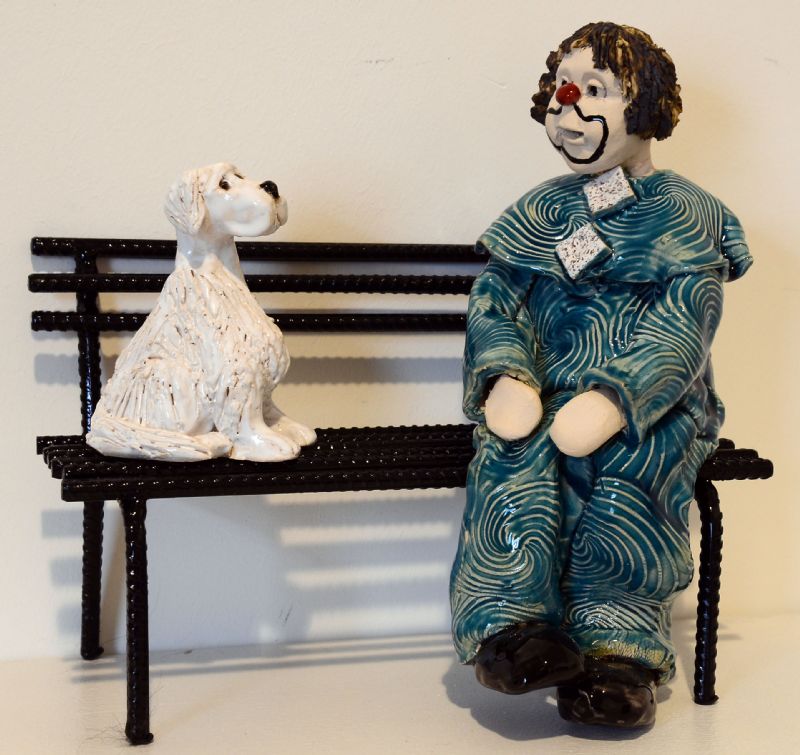 Klovn med hund på bænk