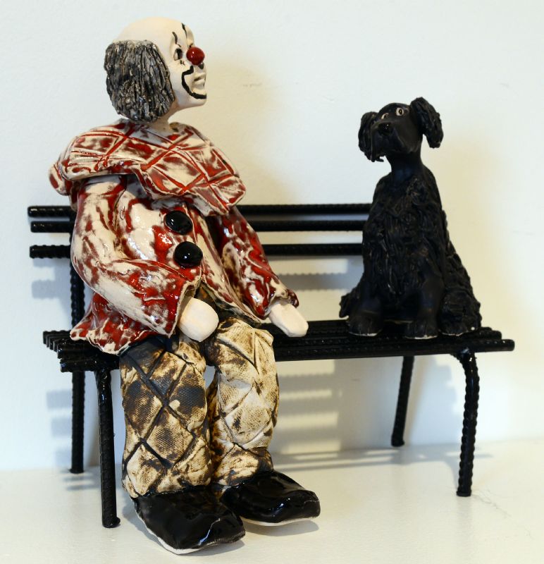 Klovn med hund på bænk