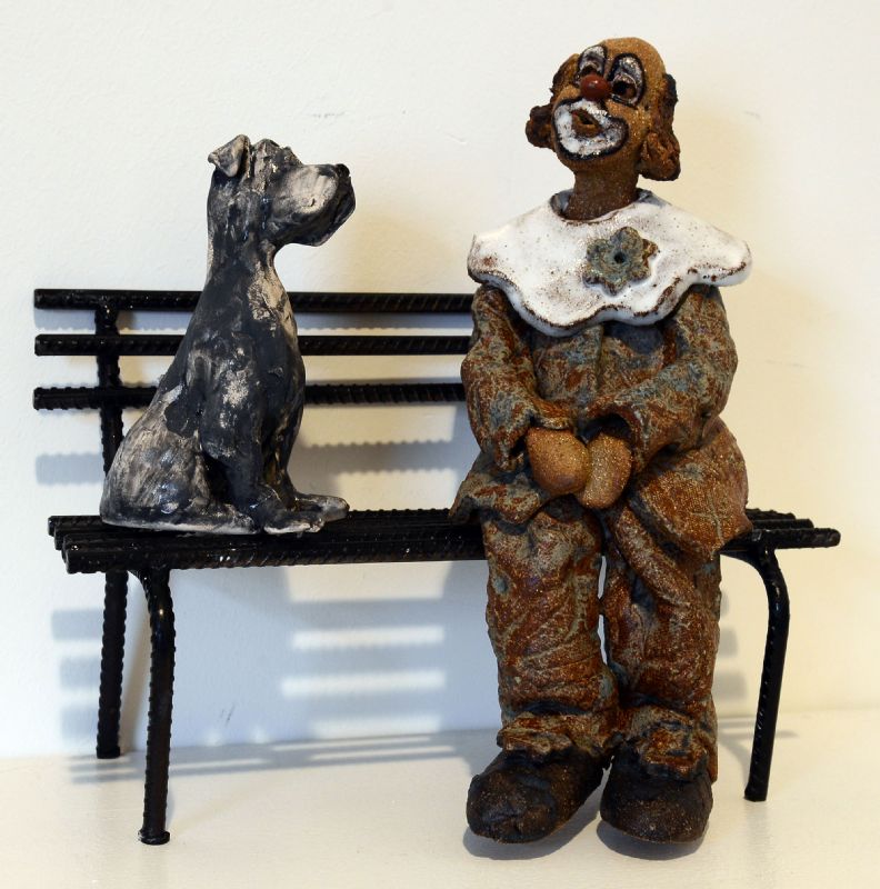 Klovn med hund på bænk