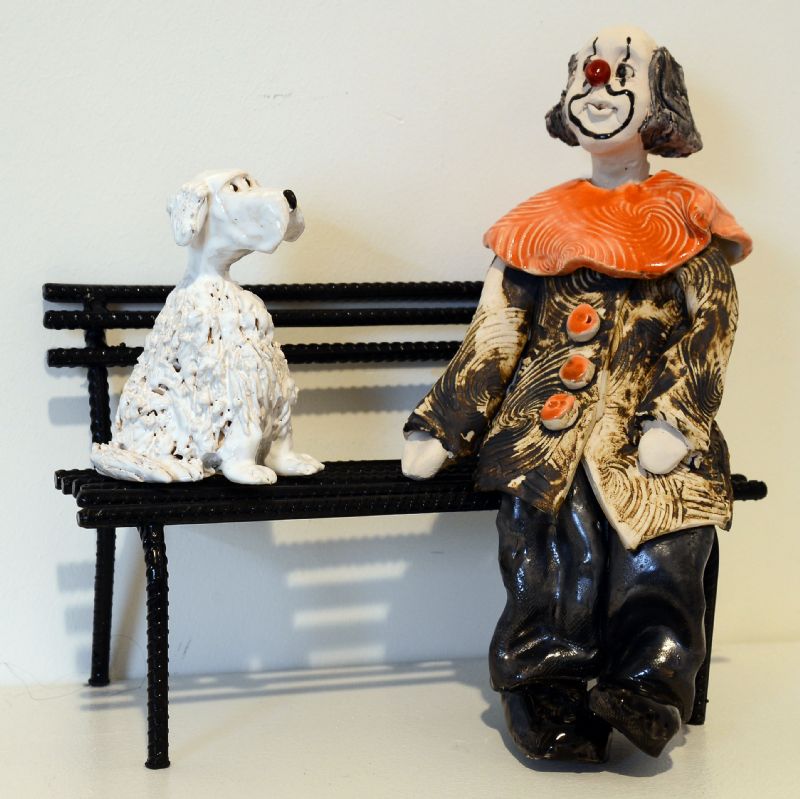 Klovn med hund på bænk