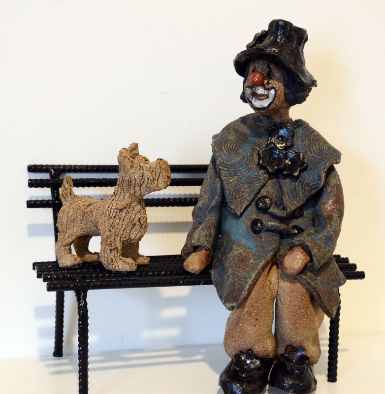 Klovn med hund på bænk
