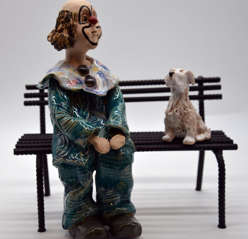 klovn med hund på bænk