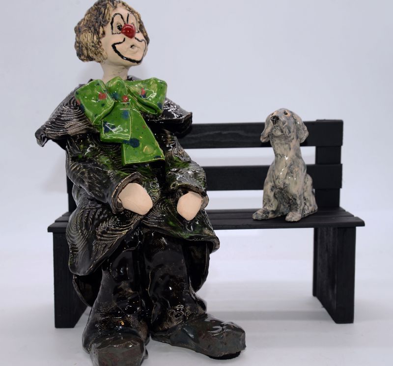 klovn med hund på bænk