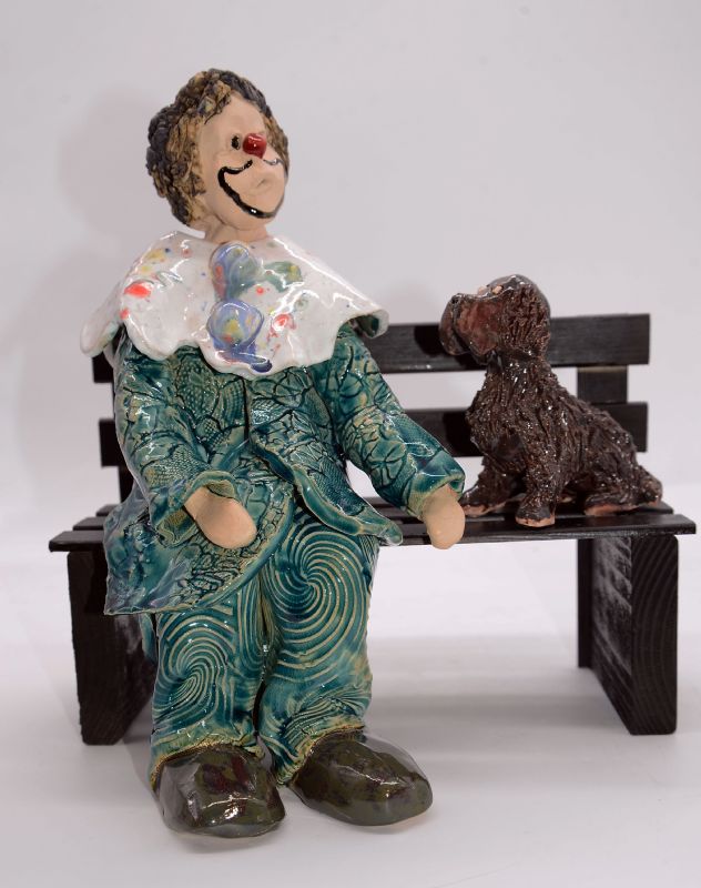 klovn med hund på bænk